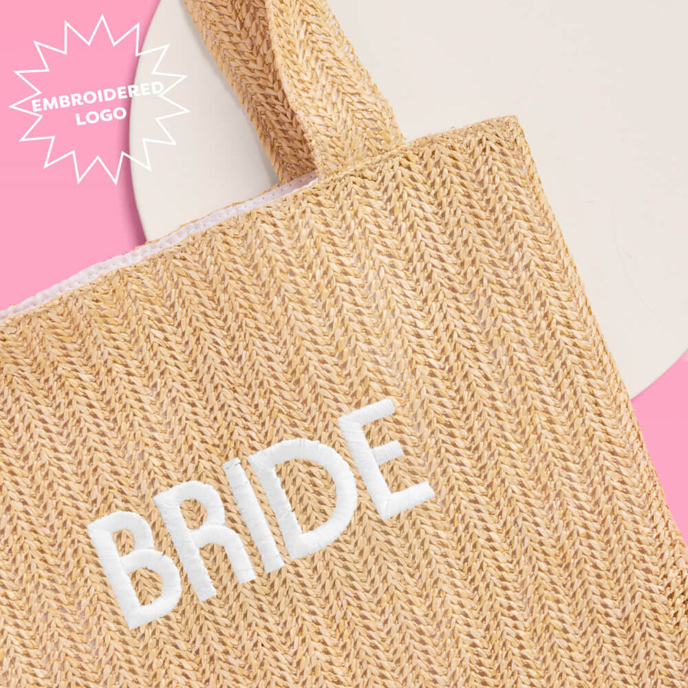 Beige tote bag with 'BRIDE' embroidery on a pink background