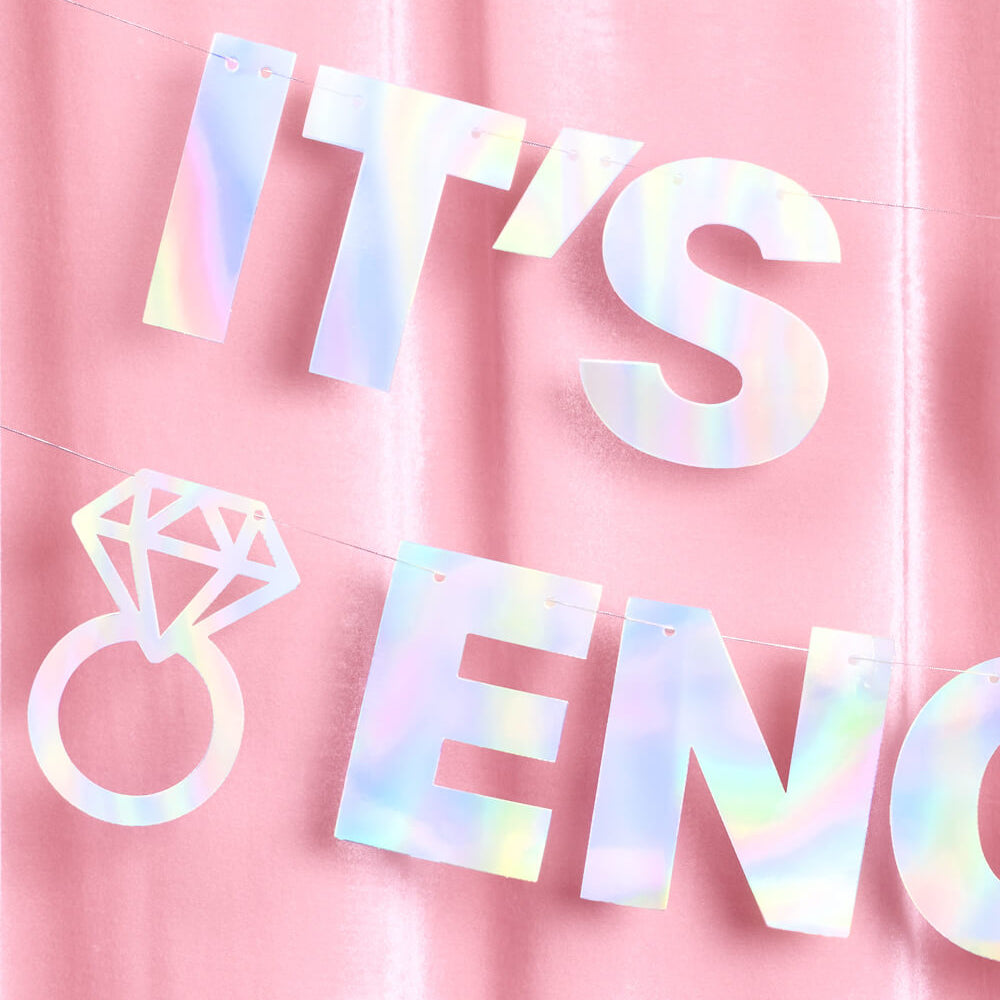 Holographic 'It's Engaged' banner on a pink background