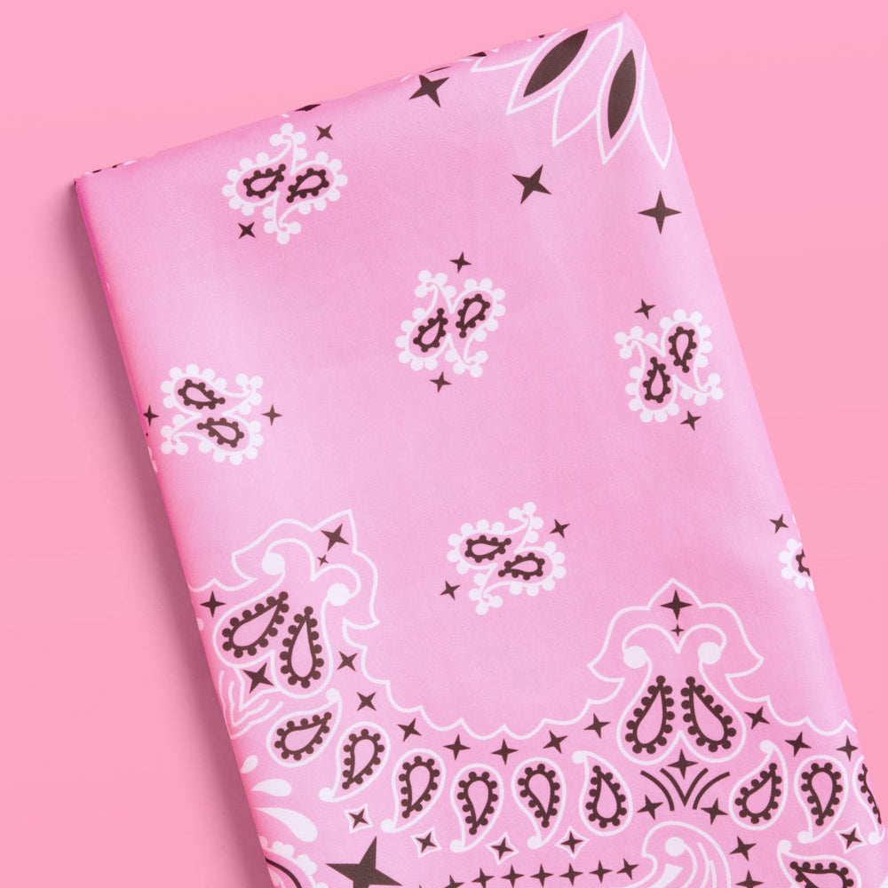 Pink bandana with black paisley pattern on a pink background