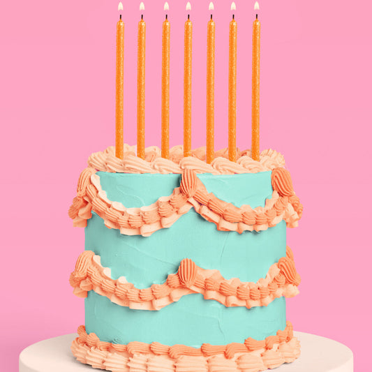 Orange glitter birthday candles on teal and peach cake for showgirl birthday theme