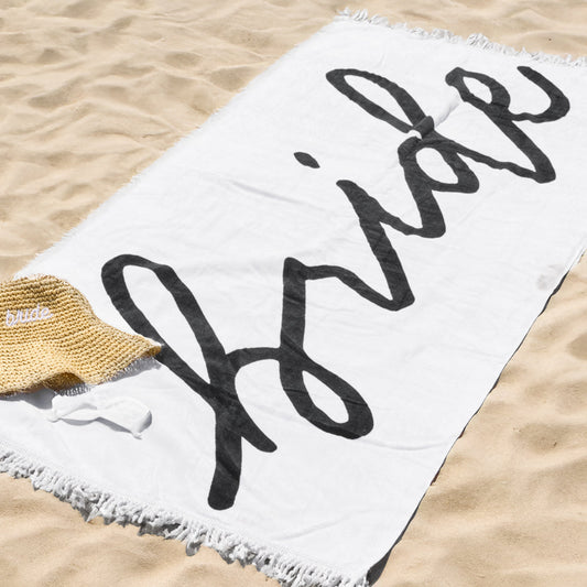 Beach towel with 'Holidaze' text on a sandy background