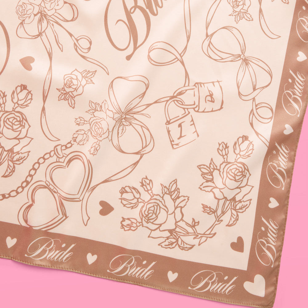 Decorative scarf with 'Bride' text and floral patterns on a pink background