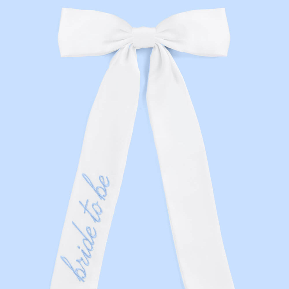 White sash with 'bride to be' text on a light blue background
