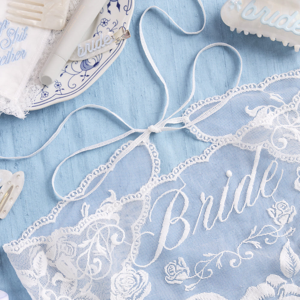 Lace fabric with 'Bride' embroidery on a blue background