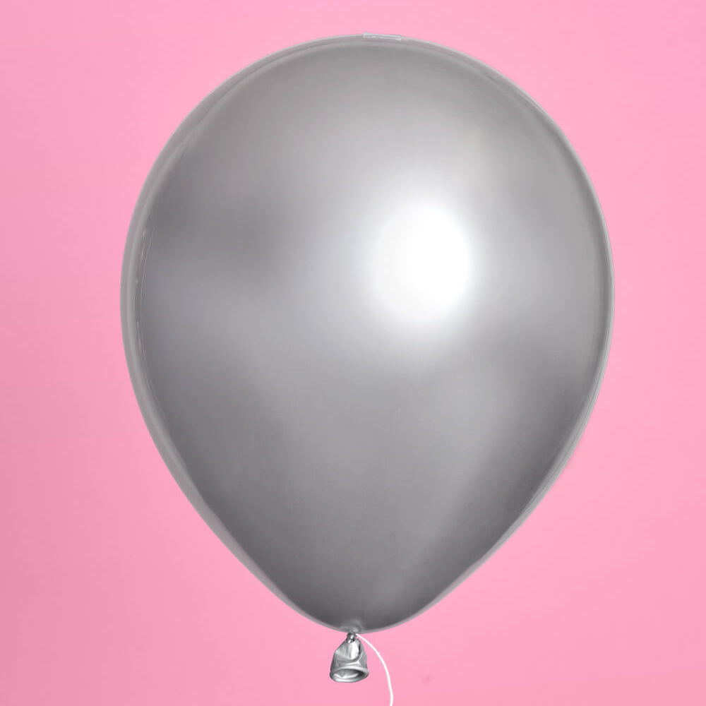 Silver balloon against a pink background