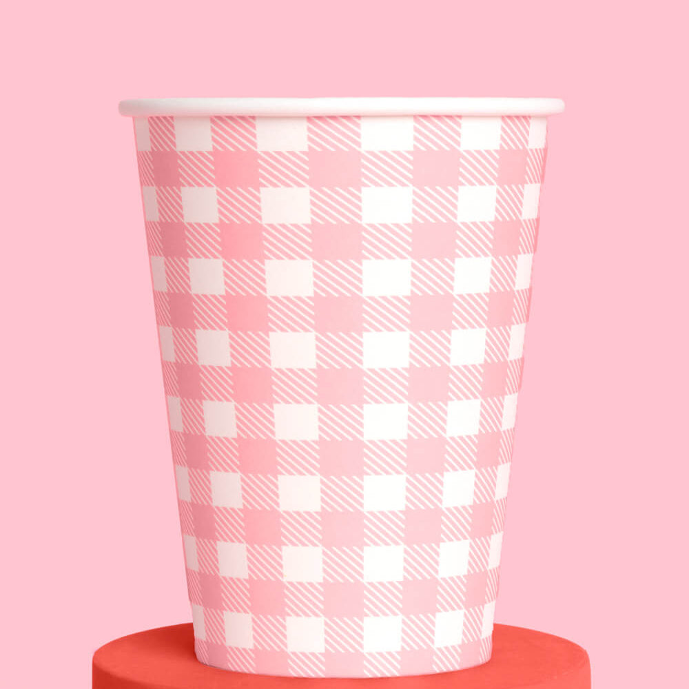 Pink and white checkered paper cup on a pink background