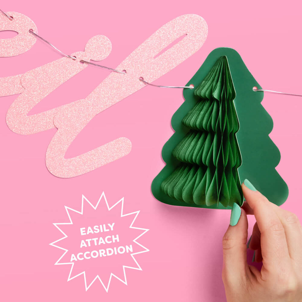 Green paper accordion decoration on a pink background with text