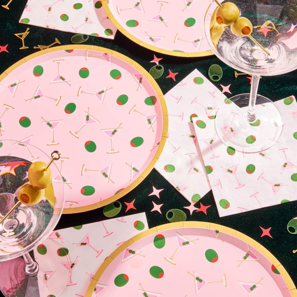Pink martini party plates with gold foil details styled with cocktails and olives