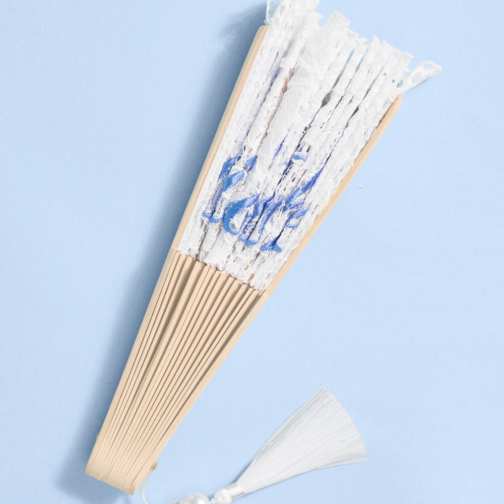 Handheld fan with white and blue design on a light blue background