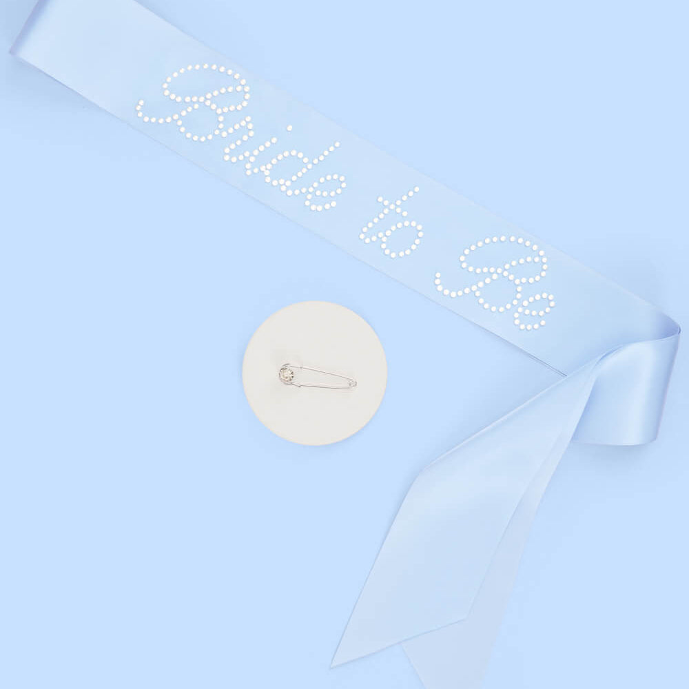 Bridal sash with 'Bride to be' text on a light blue background