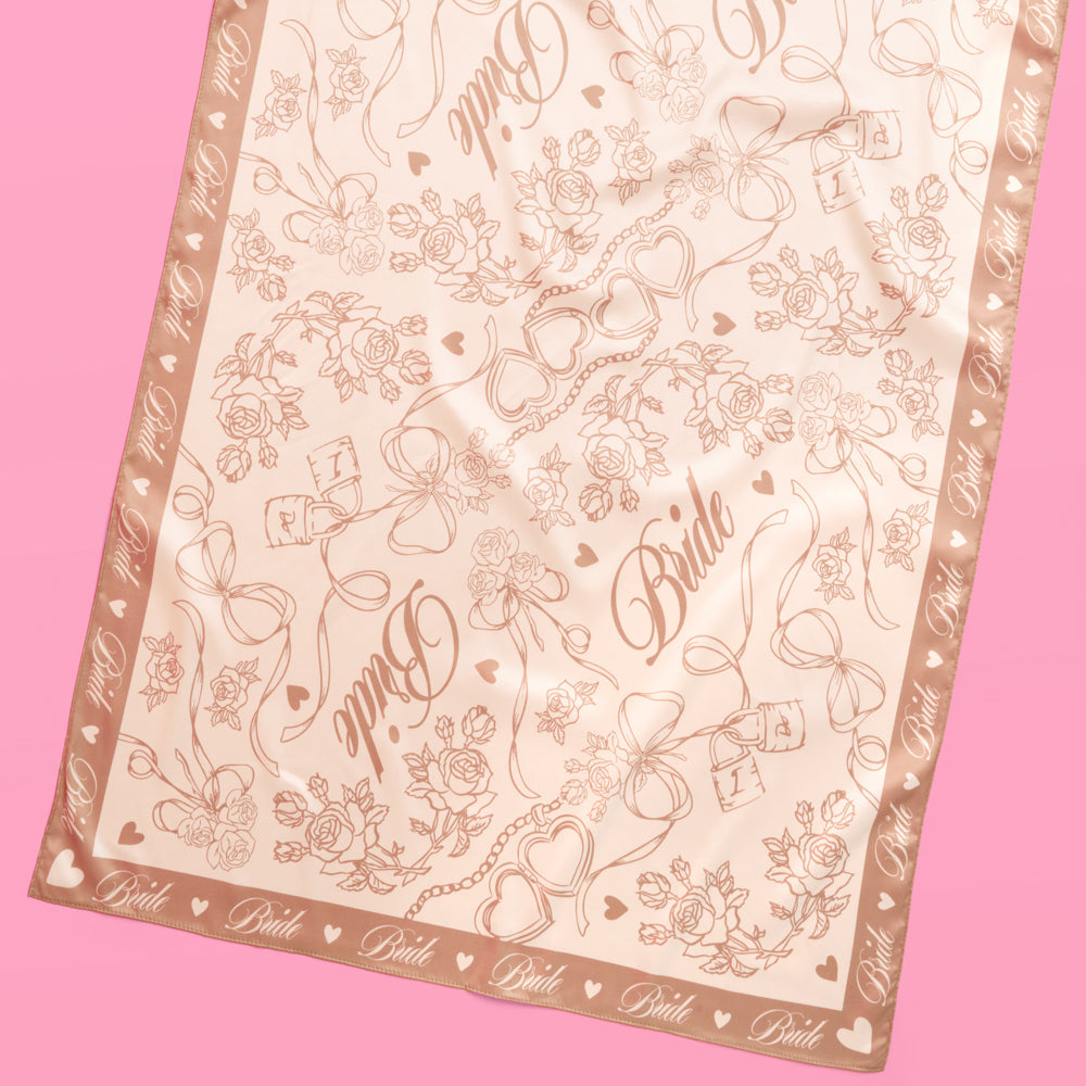 Decorative scarf with floral and heart patterns on a pink background