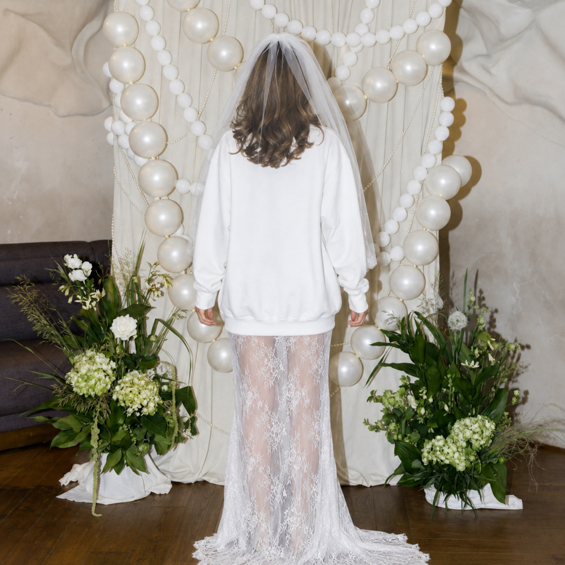 Back view of bride wearing white crewneck sweatshirt and bridal veil