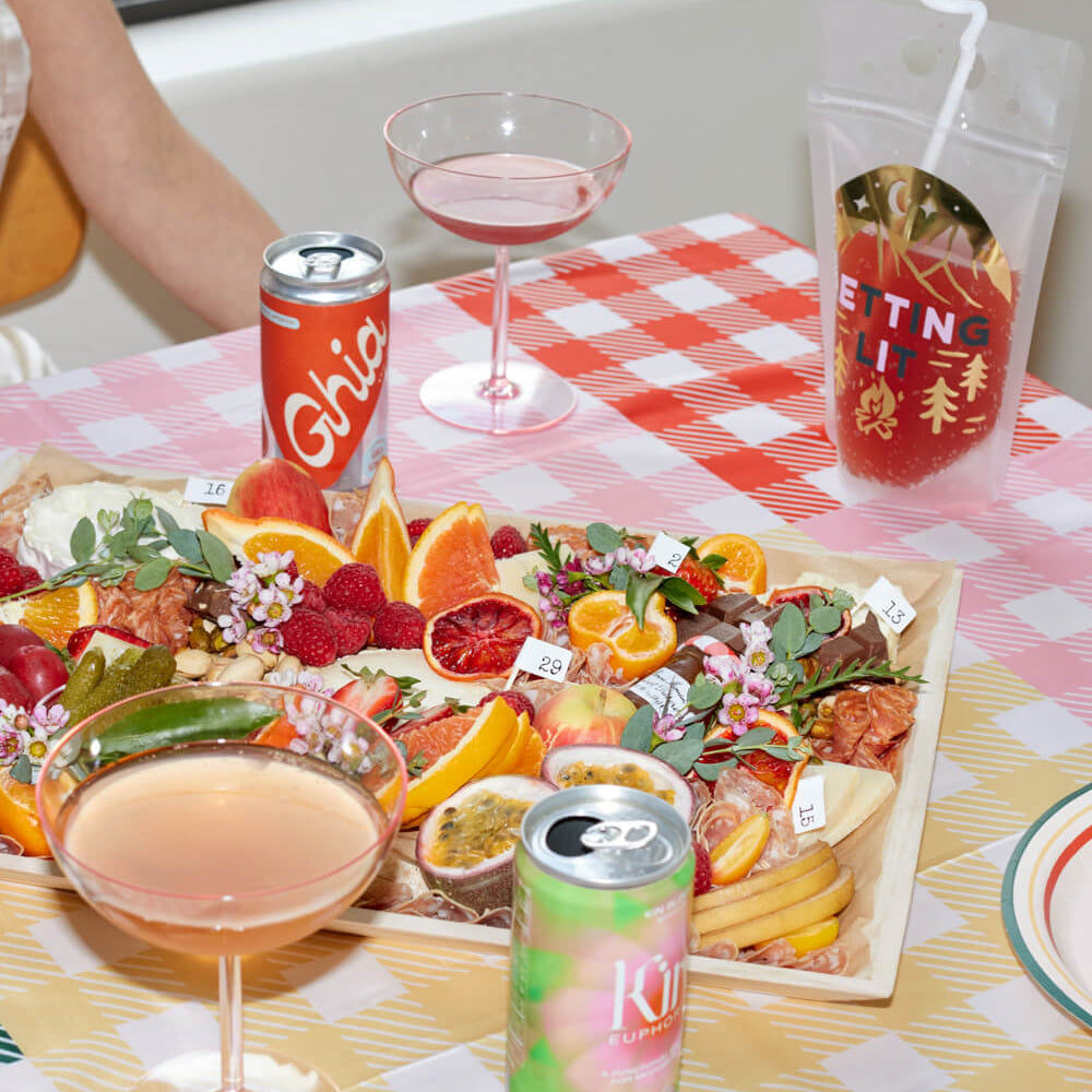 Camp Bride gingham tablecloth styled for outdoor bachelorette picnic setup