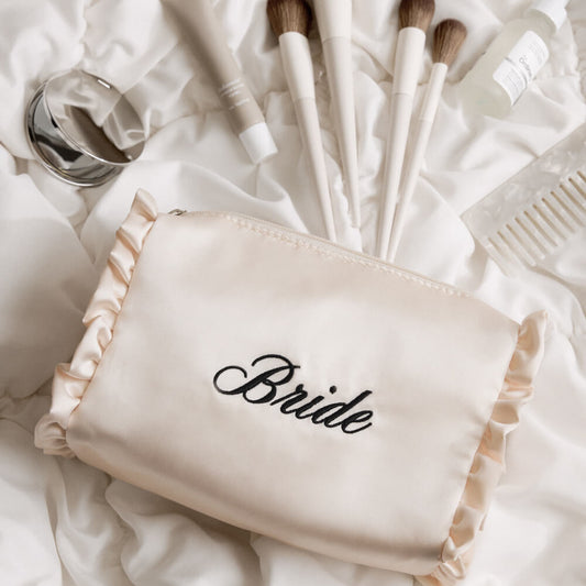 Makeup brushes with a 'Bride' pouch on a soft white background