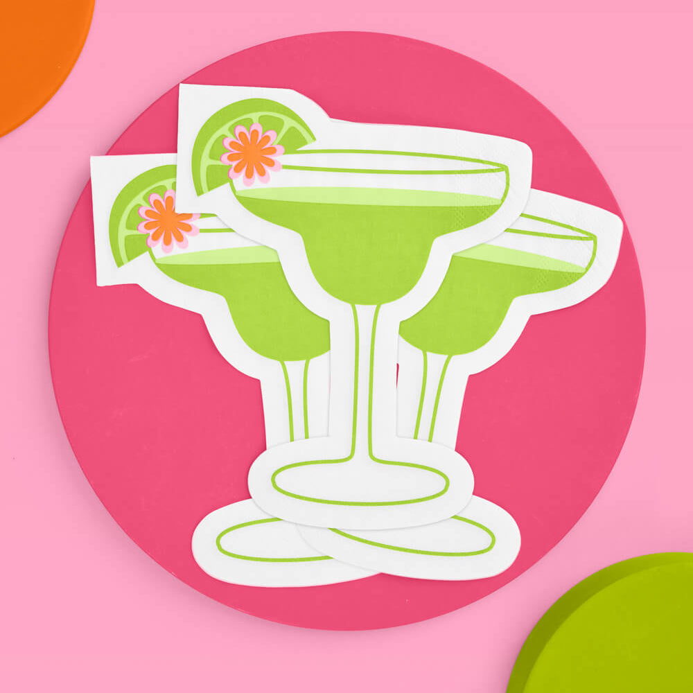  green margarita glass  napkin  with lime and cherry on a pink background