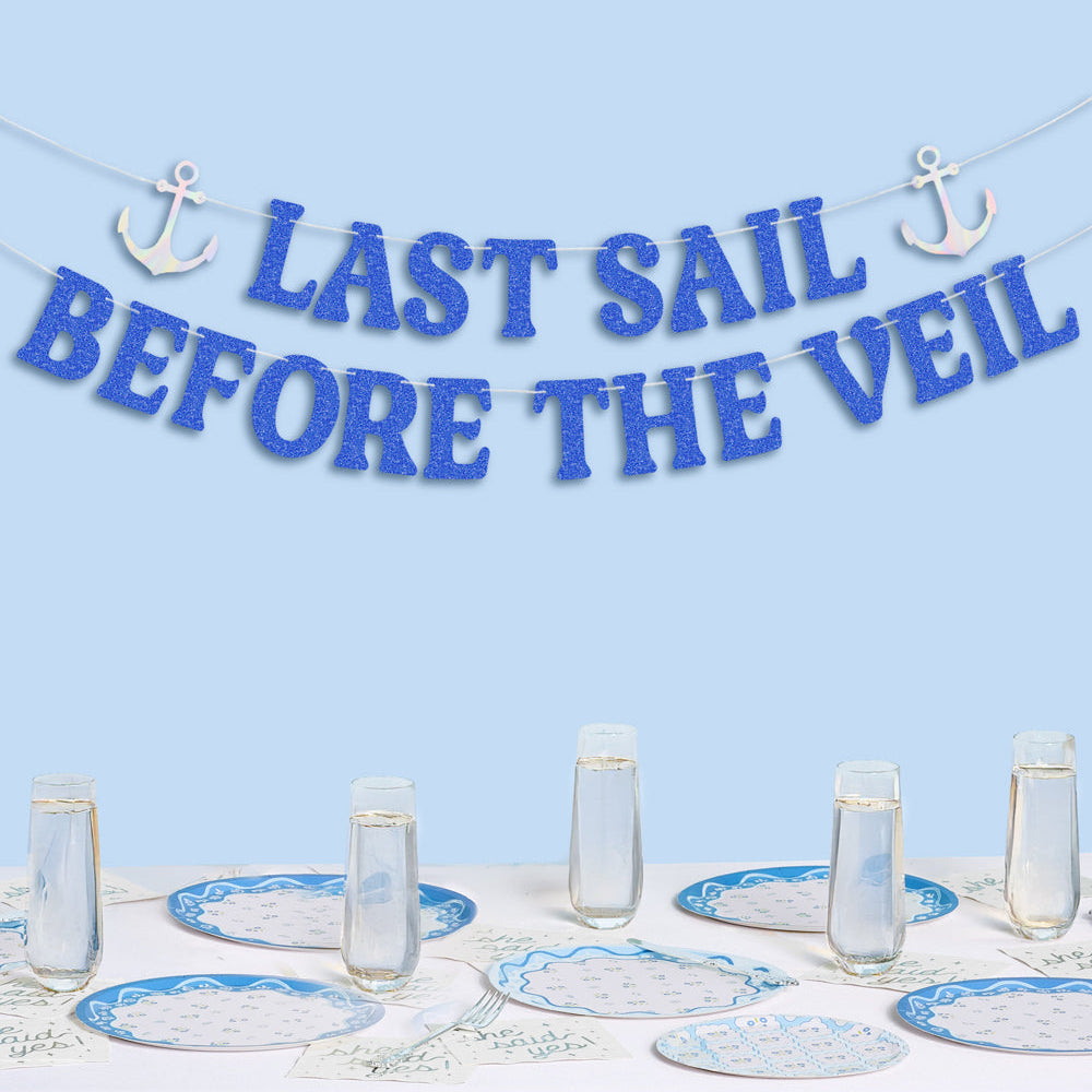 Table setting with 'Last Sail Before the Veil' banner on a light blue background