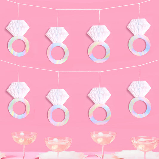 Decorative diamond ring garland on a pink background with table settings.