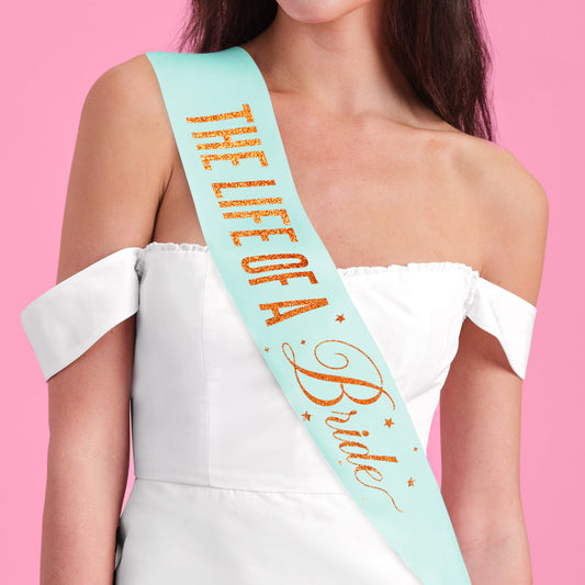 Woman wearing a 'The Life of a Bride' sash against a pink background
