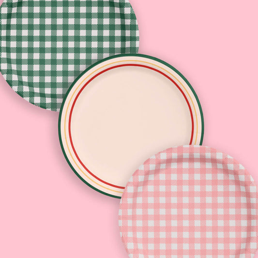 Three round paper plates with green and white checkered, beige with red and green rim, and pink and white checkered patterns on a pink background.