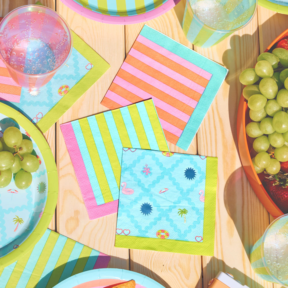 Colorful plates, napkins, and snacks on a wooden table