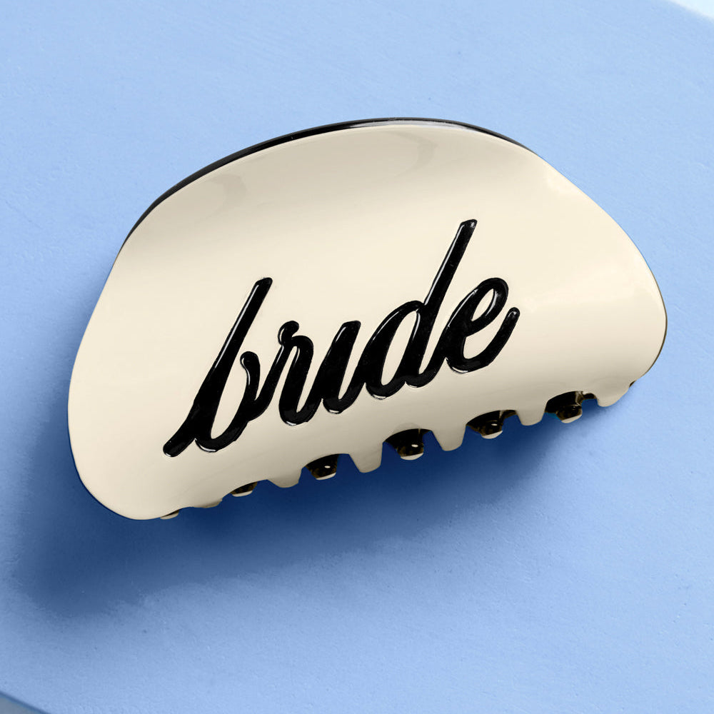 Bride wearing ivory claw clip with black bride logo styled half-up for bridal shower or bachelorette event