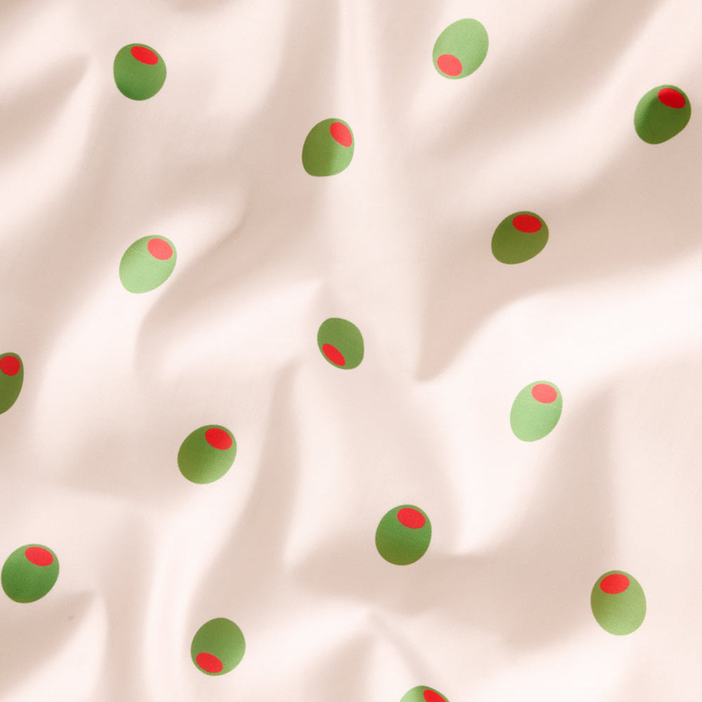 Pattern of green and red circles on a beige fabric background