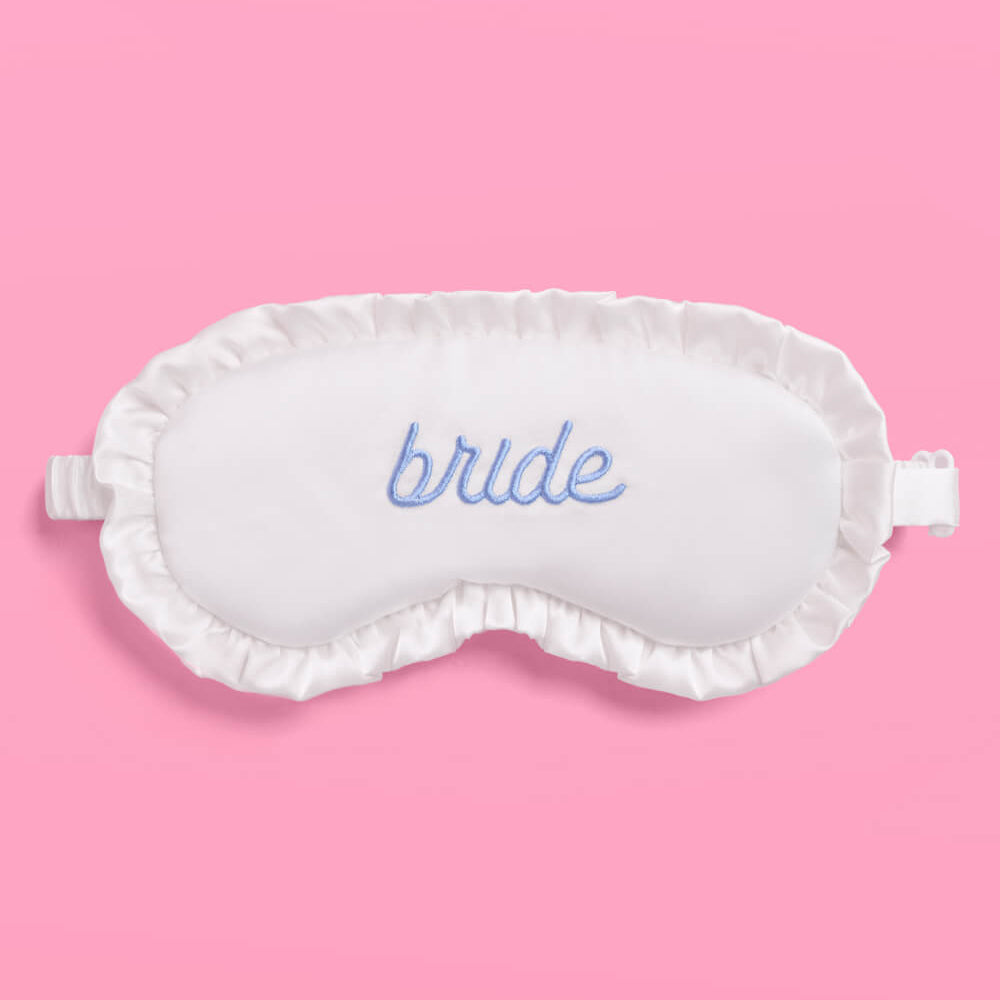 White sleep mask with 'bride' embroidery on a pink background