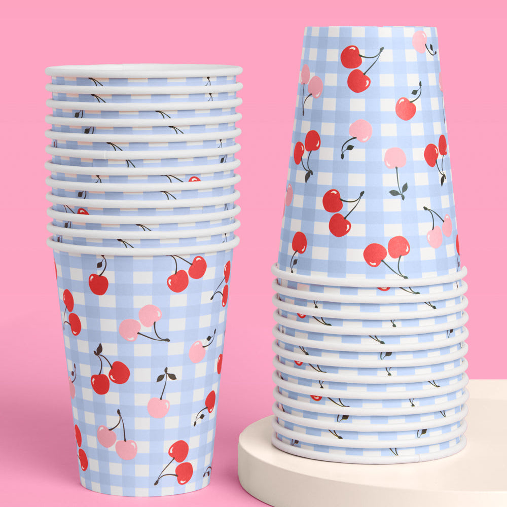 Stacks of paper cups with cherry pattern on a pink background
