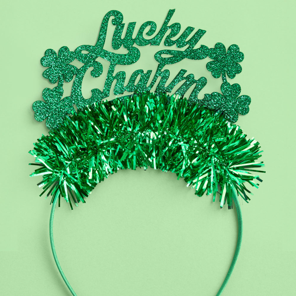 Green festive headband with 'Lucky Charm' text and tinsel on a light green background
