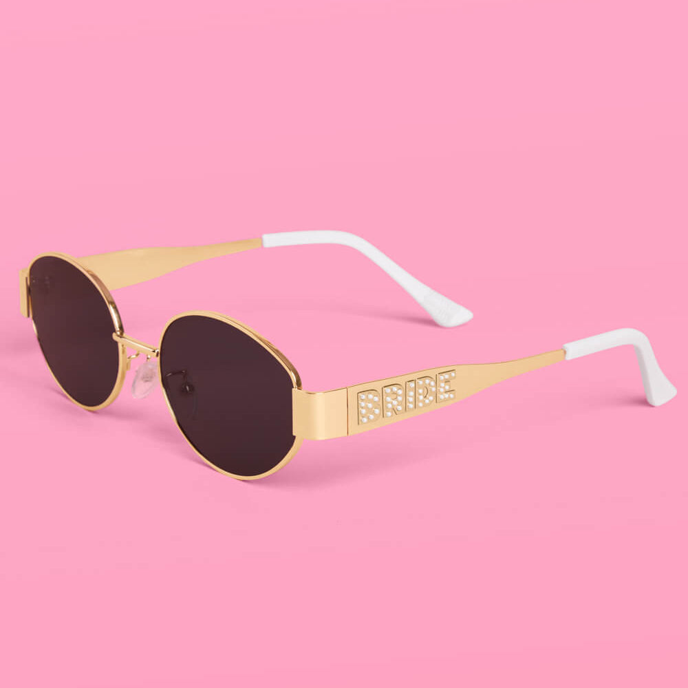 Sunglasses with 'Bride' on the frame against a pink background