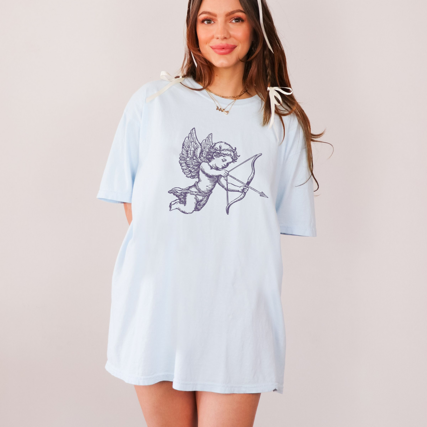 Model wearing chambray blue Cupid arrow graphic t-shirt styled oversized for Valentine’s Day
