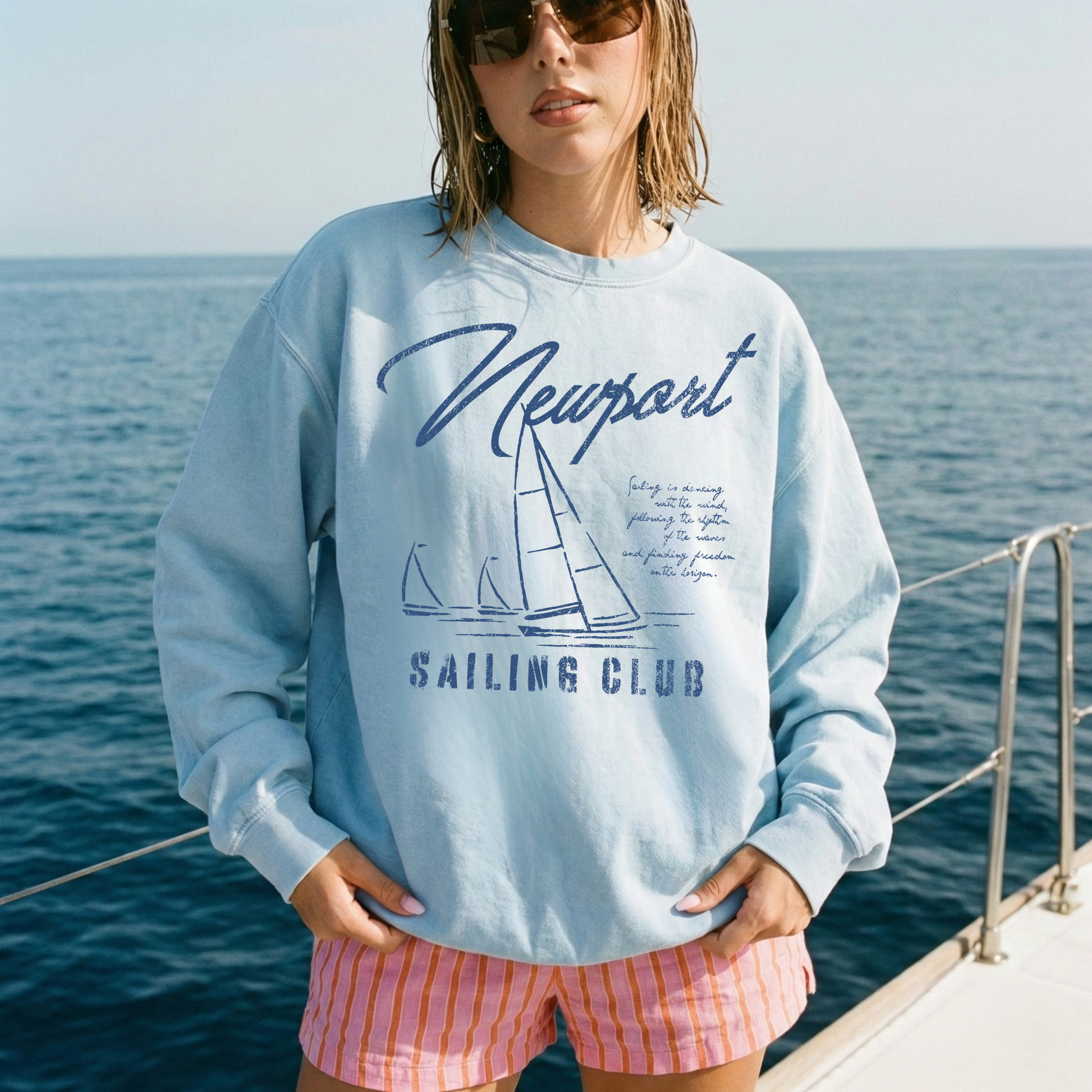 woman wearing blue newport sailing club sweatshirt on a boat coastal summer outfit nautical style