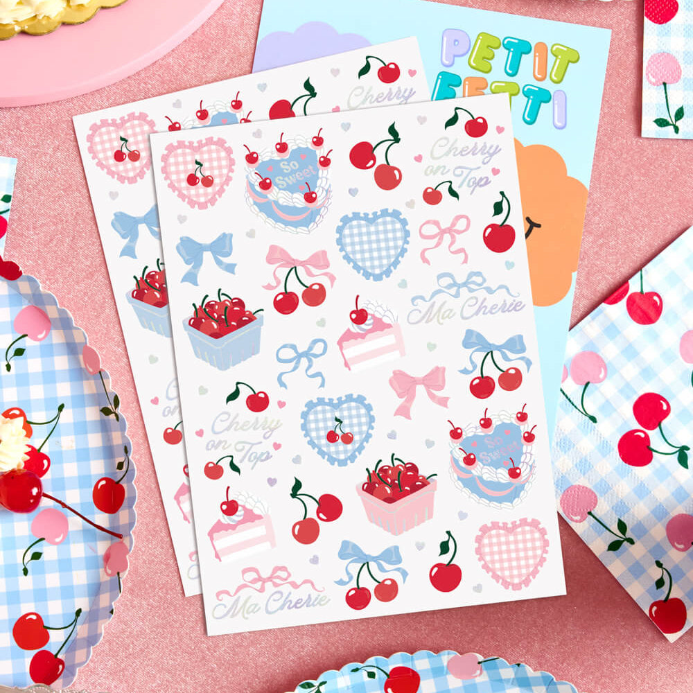 Sticker sheets with cherry and bow designs on a pink background