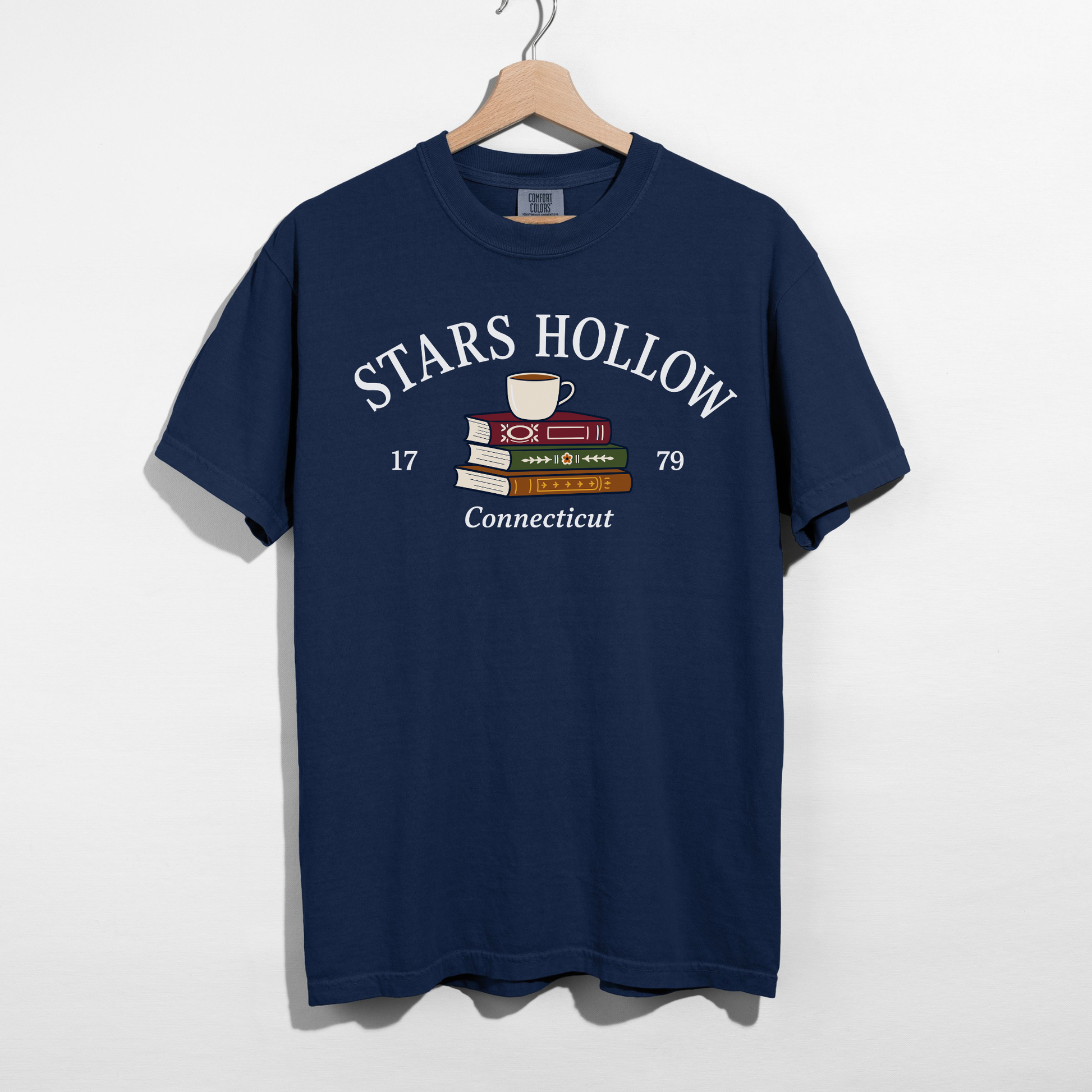 True Navy Stars Hollow Connecticut graphic t-shirt featuring stacked books and a coffee cup with vintage-inspired lettering.