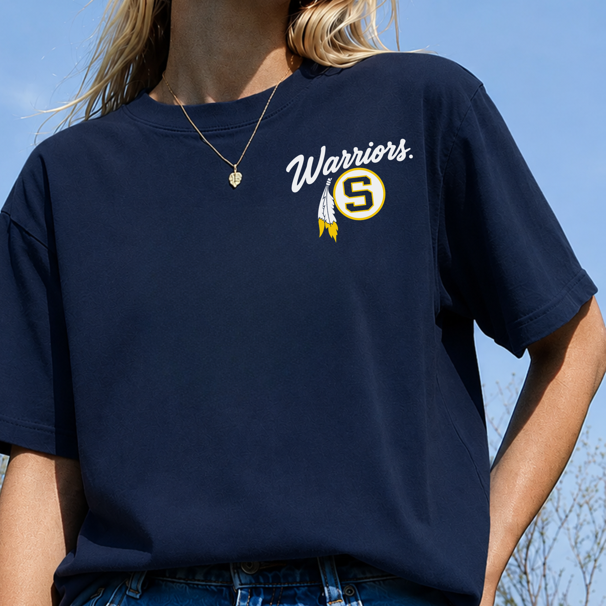 Woman wearing true navy Sterling Warriors shirt with white Warriors script, Sterling S logo and gold feather chest graphic.