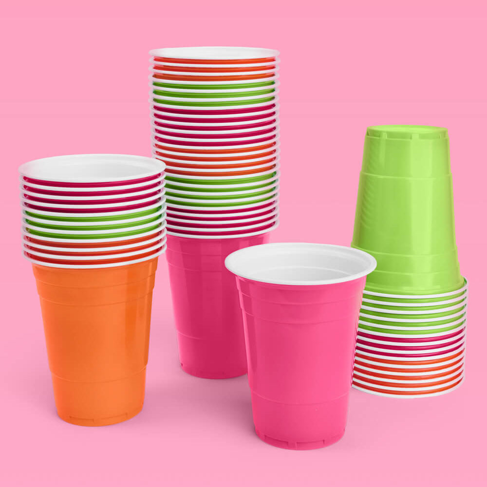Colorful paper cups including striped and solid designs on a pink background