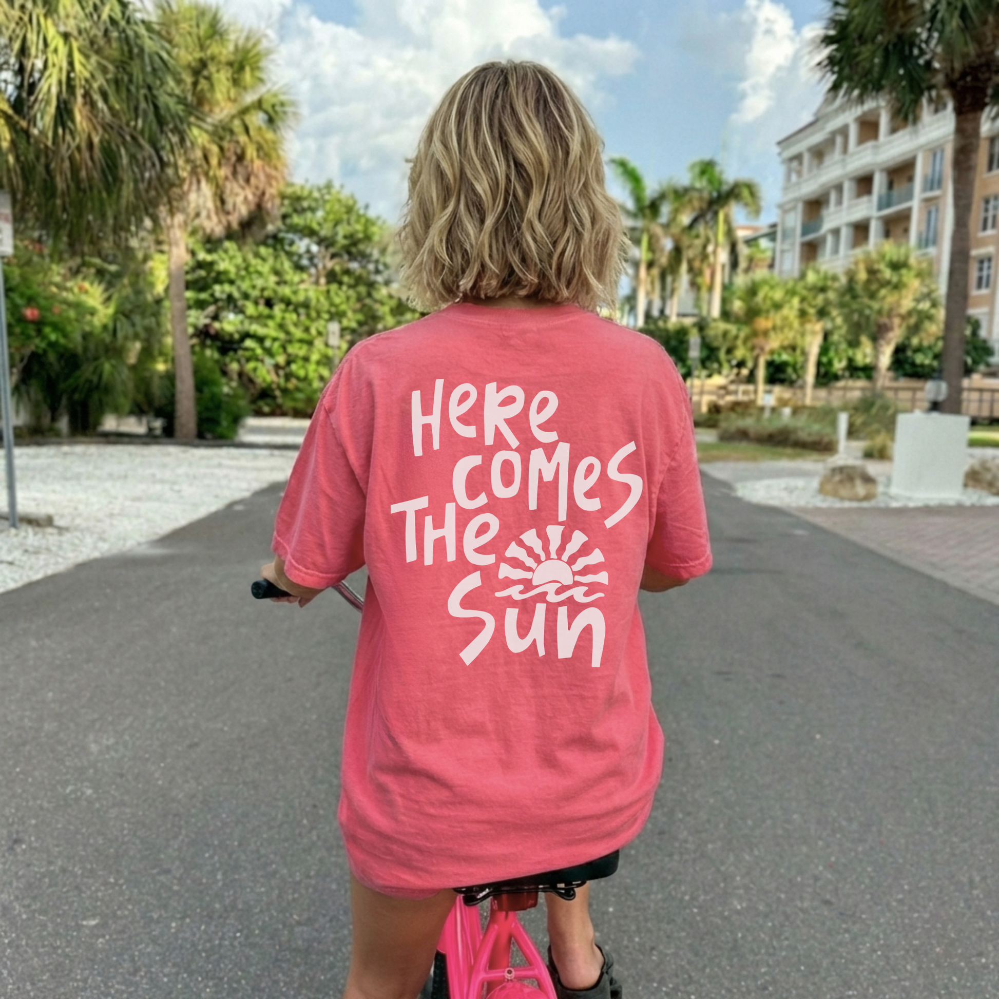 Back view of watermelon pink Here Comes The Sun graphic t-shirt with large retro sun design
