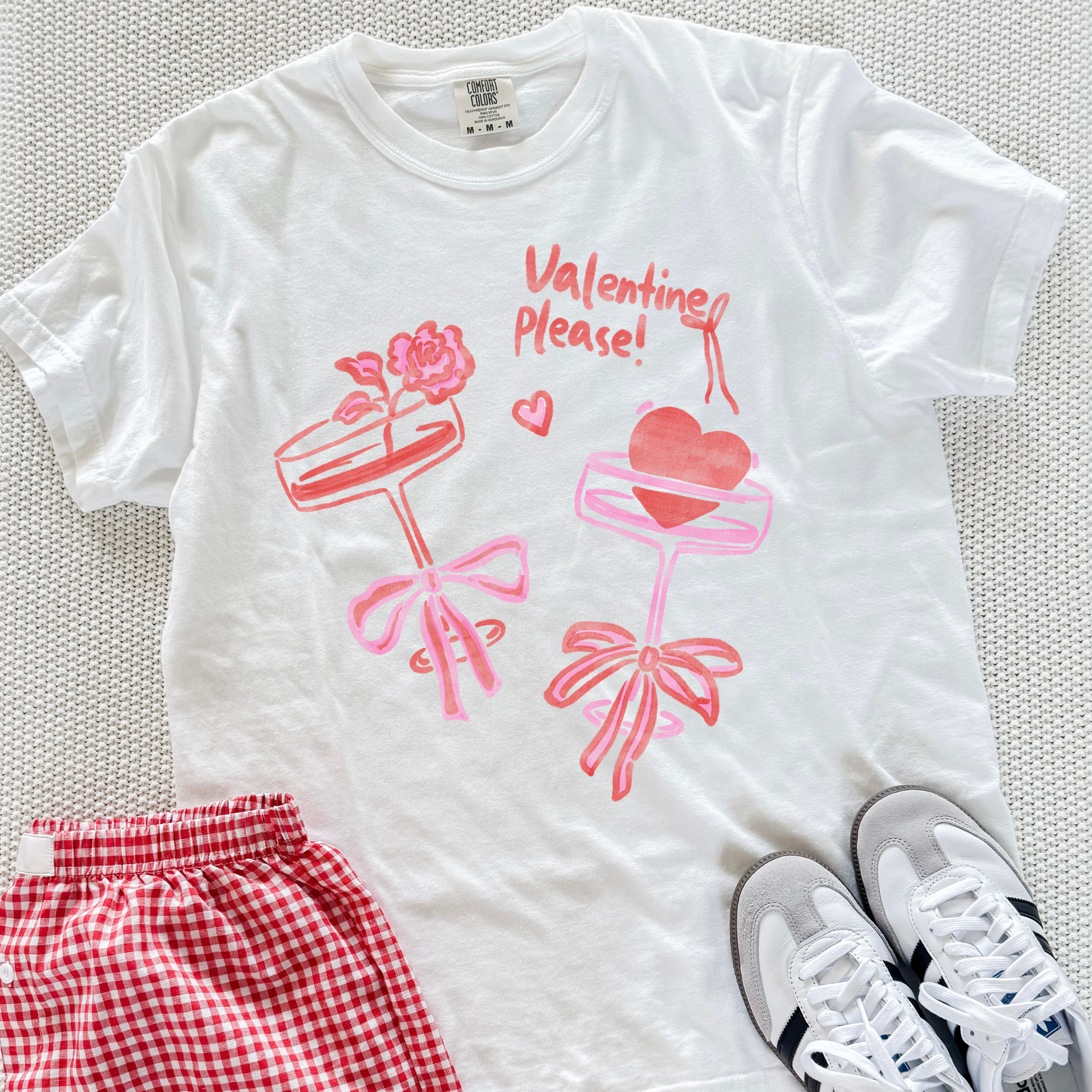 White Valentine Please graphic tee styled with red gingham shorts and sneakers.