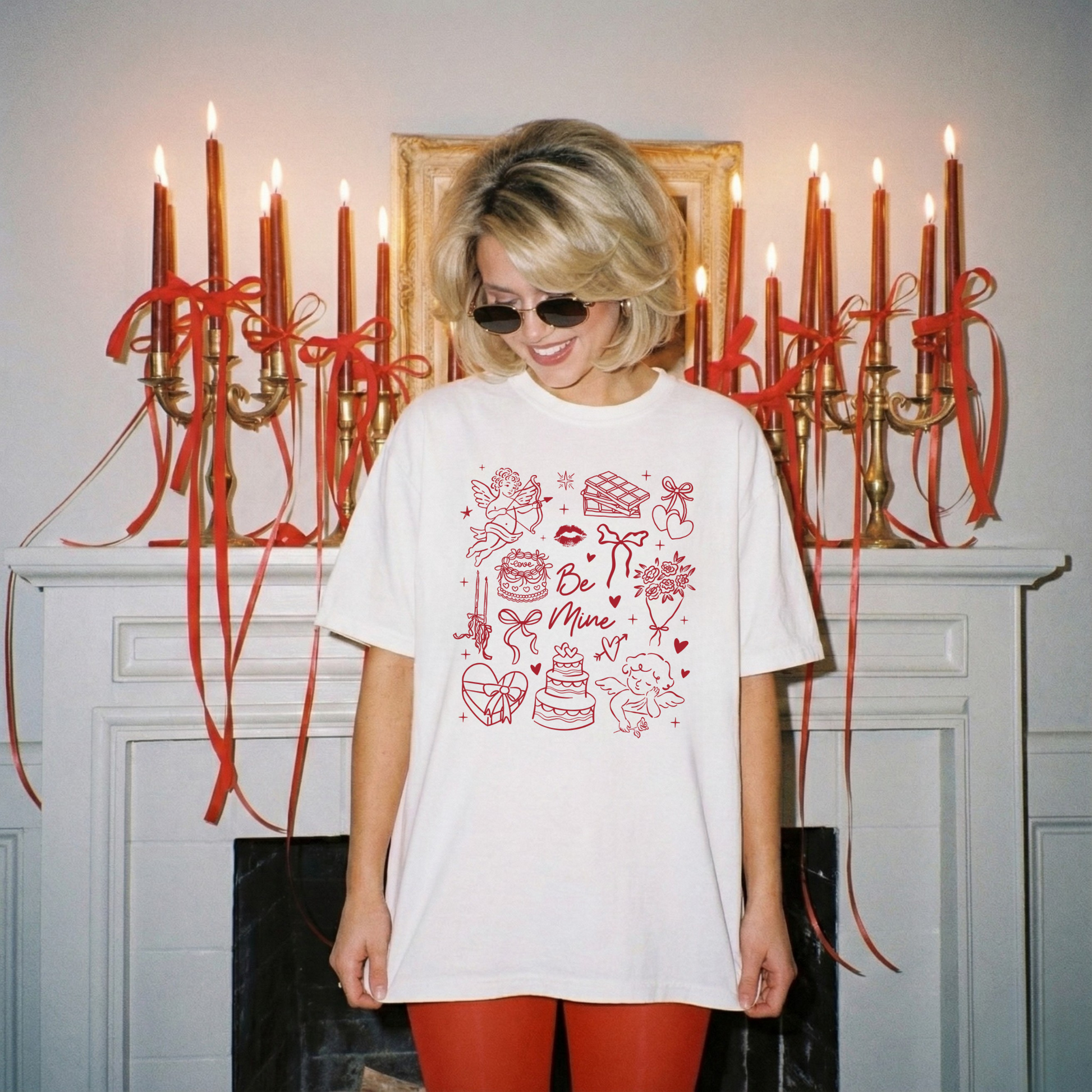 Model looking down wearing white Valentine graphic tee in front of red candles