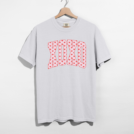 White Comfort Colors XO heart graphic t-shirt on wooden hanger