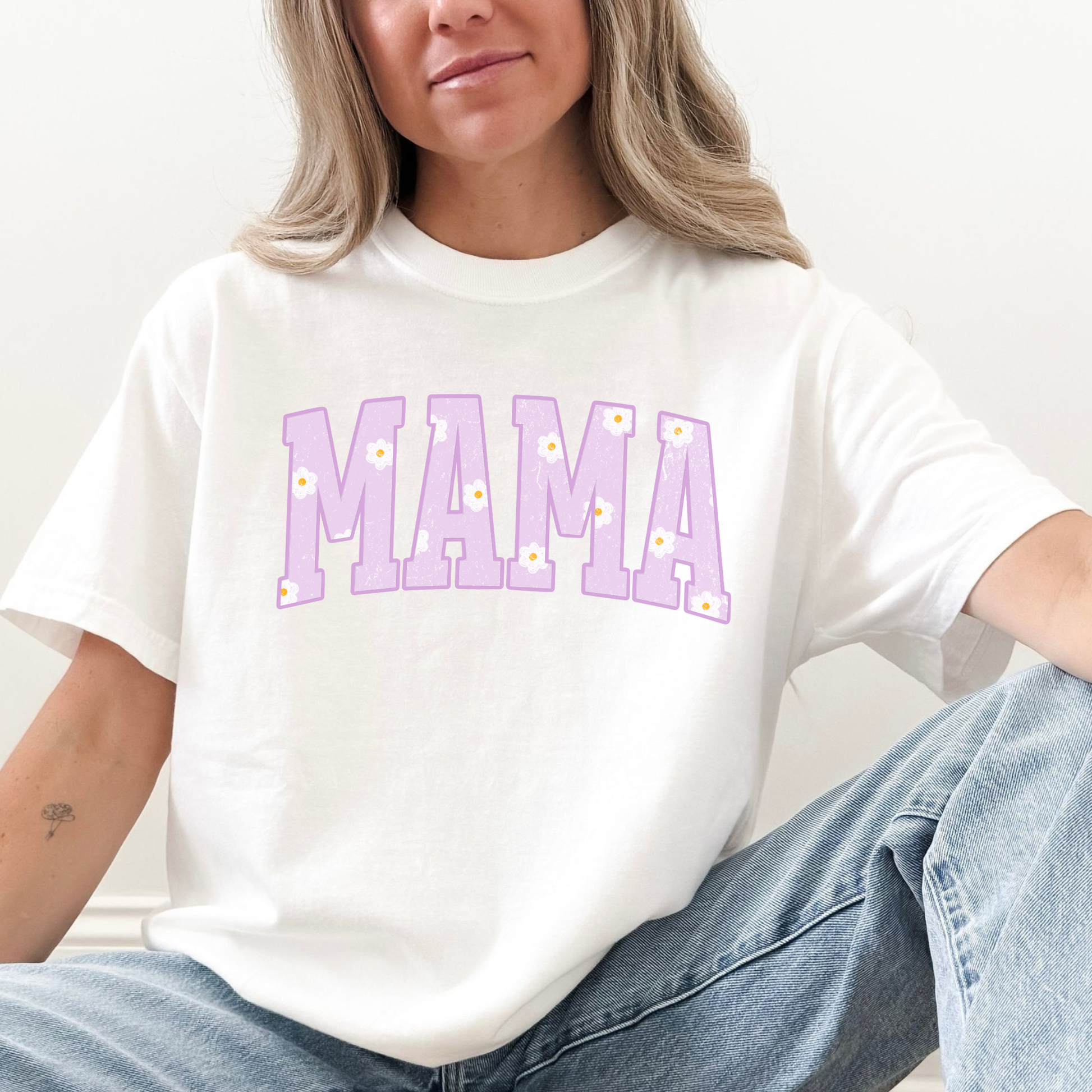 Woman wearing a white Comfort Colors mama graphic t-shirt with lavender floral collegiate letters, casual mom outfit