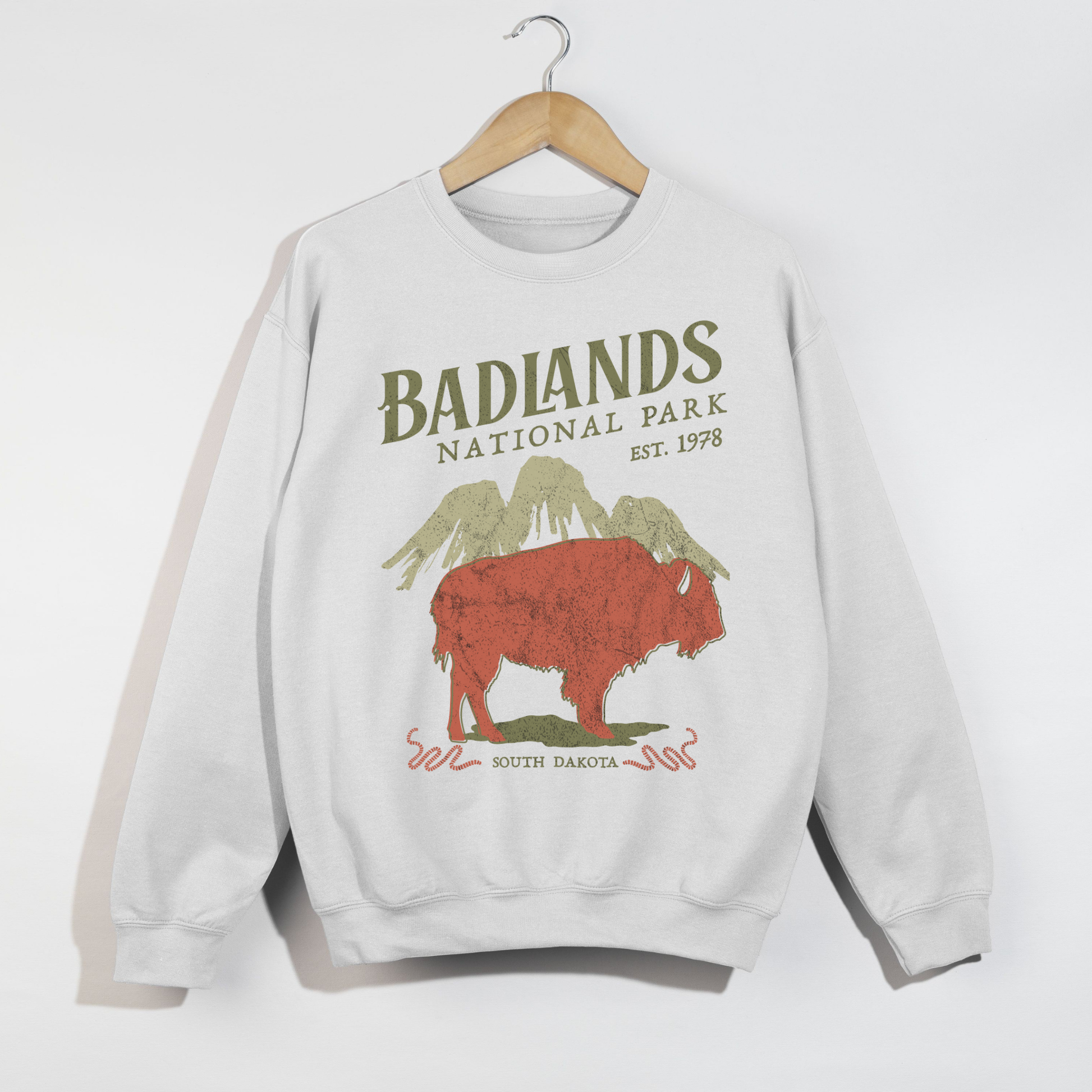 White unisex graphic sweatshirt with retro Badlands National Park buffalo artwork