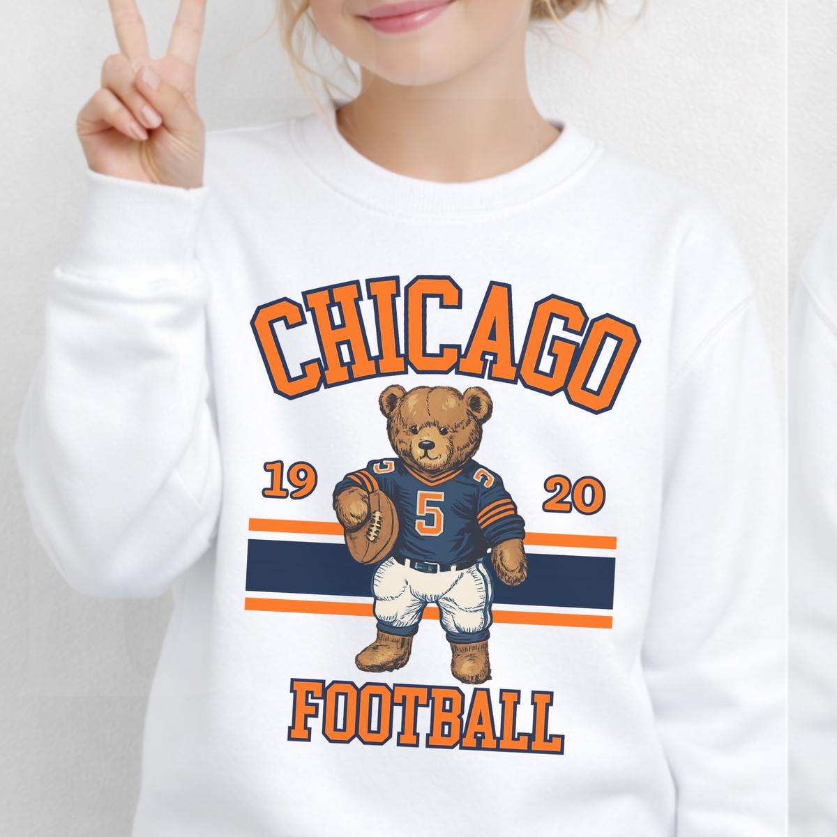 White sweatshirt with Chicago Football design featuring a bear holding a football.