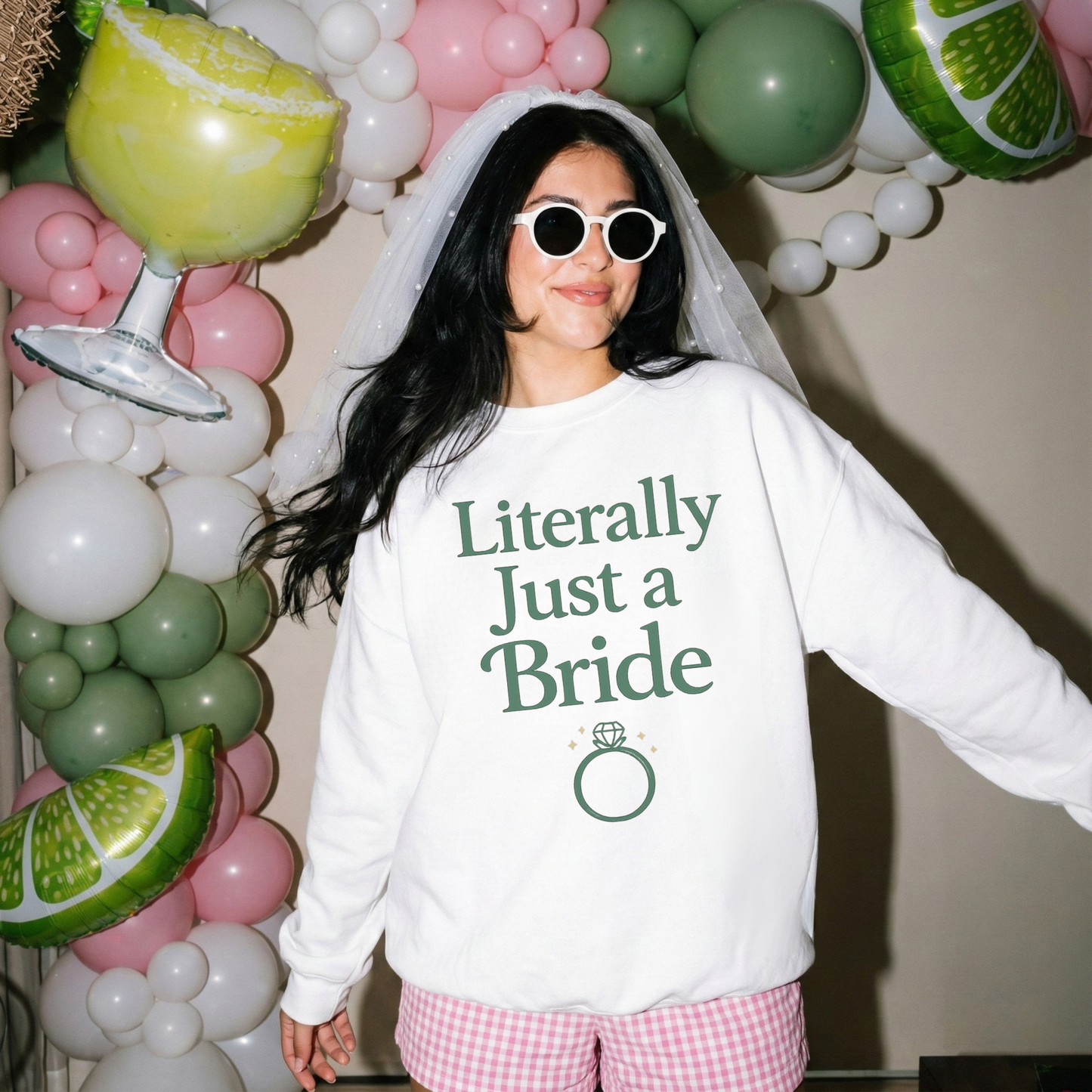 Bride wearing Literally Just a Bride sweatshirt at bachelorette party with veil