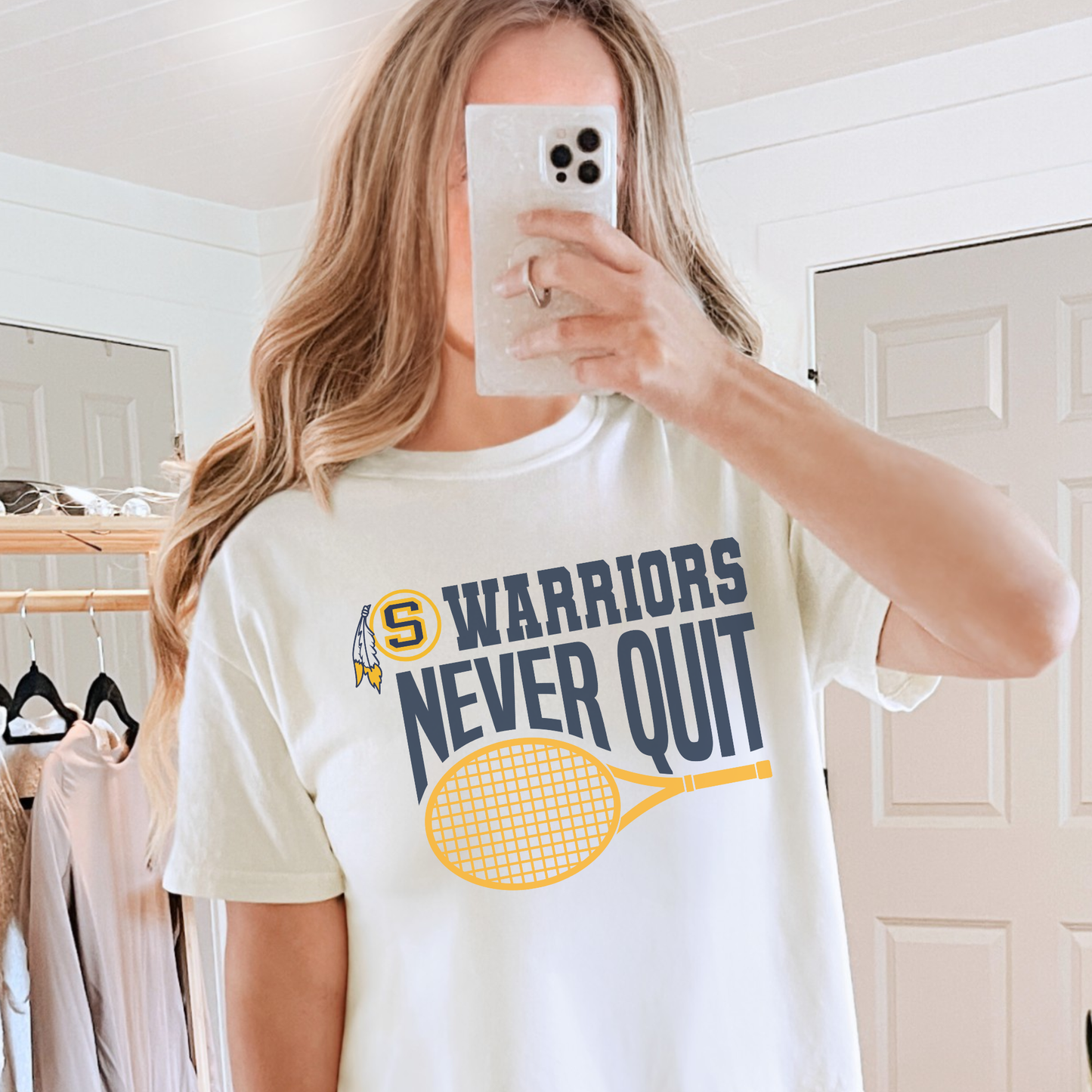 Woman wearing a white Warriors Never Quit tennis graphic t-shirt with yellow tennis racket design