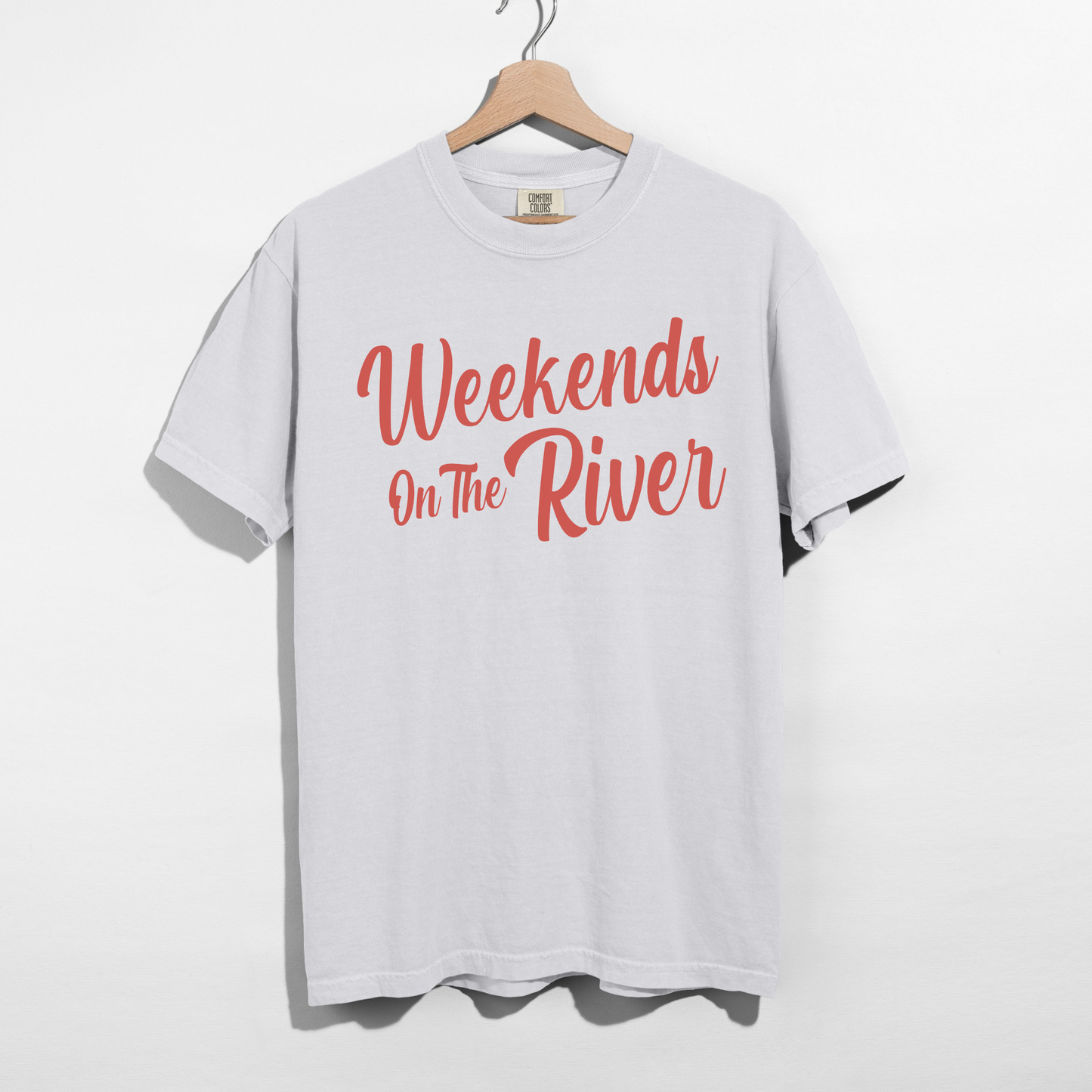 White Comfort Colors garment-dyed t-shirt with coral red “Weekends On The River” summer graphic printed on the front.