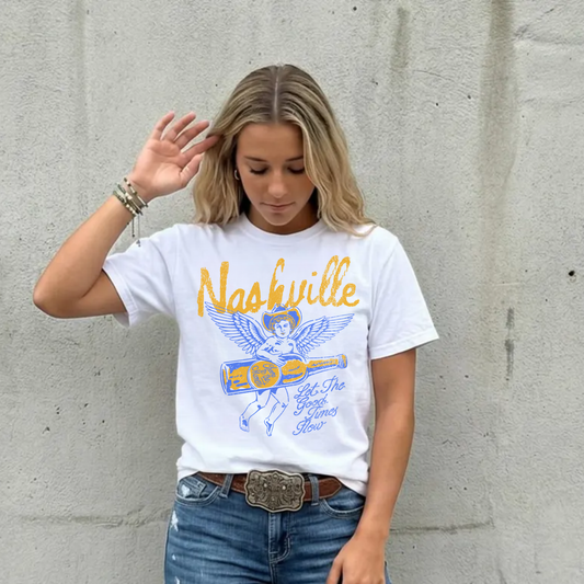 Woman wearing white Nashville graphic tee with angel design styled with jeans and western belt, country concert outfit