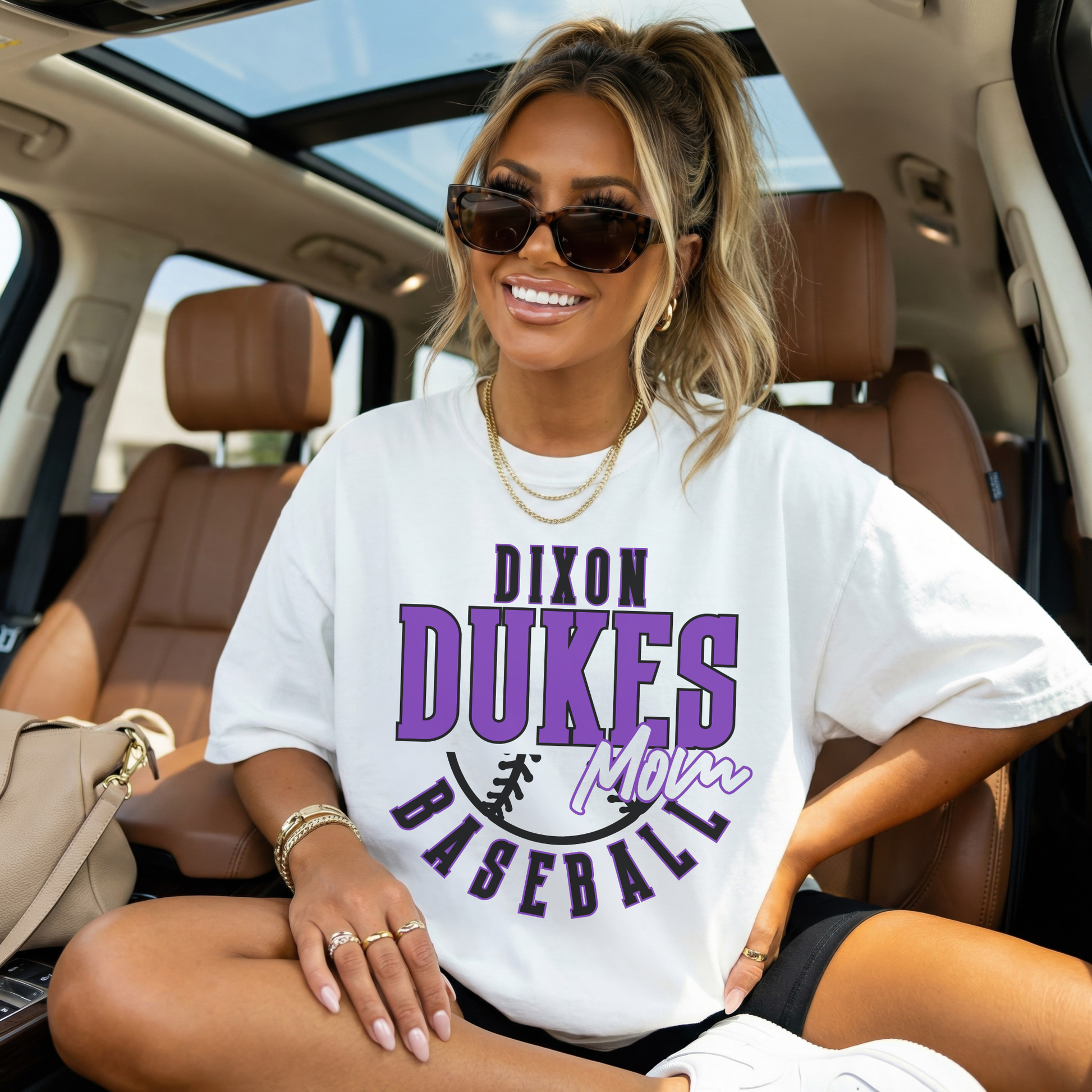 White oversized Dixon Dukes Baseball Mom tee styled in car smiling lifestyle photo