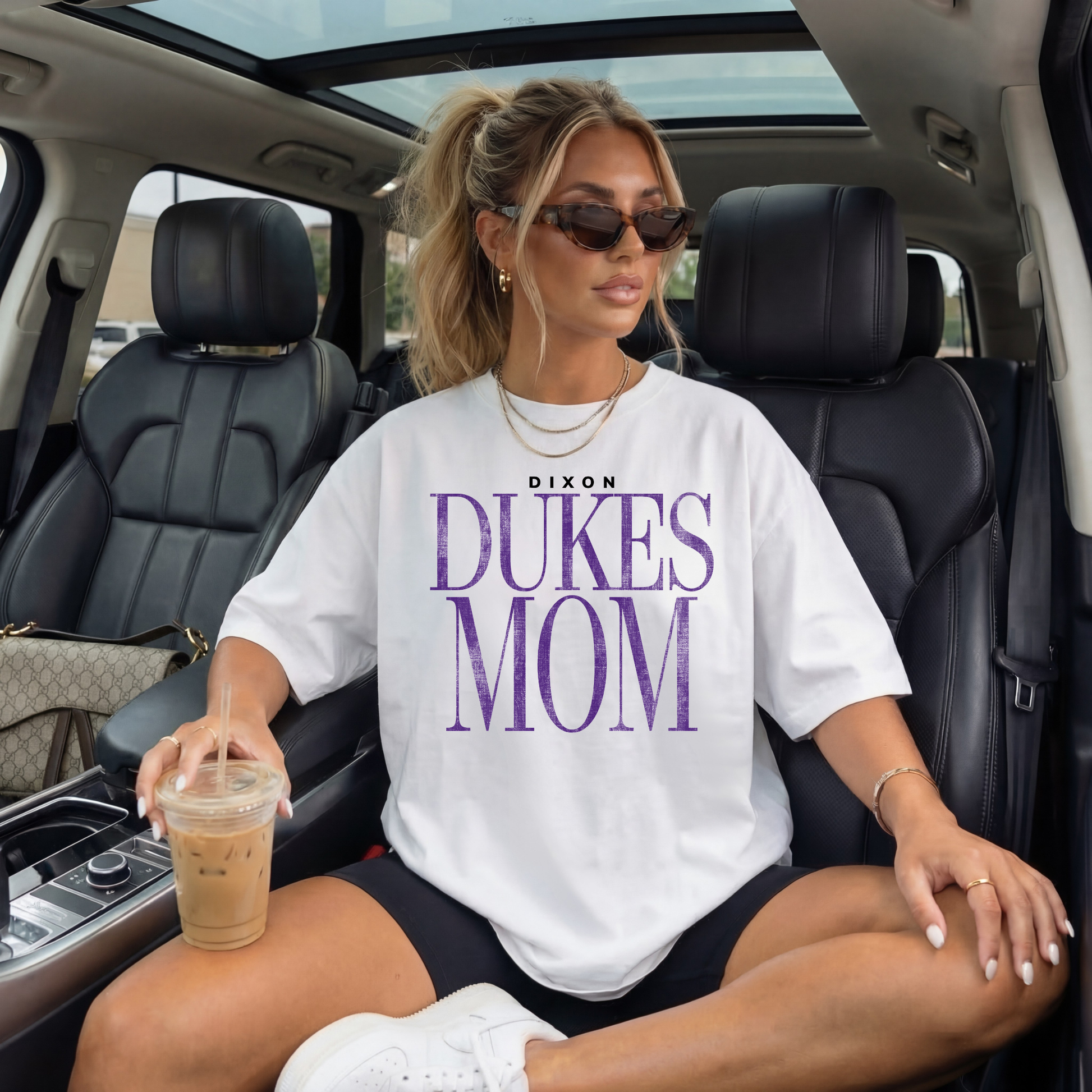 White oversized Dixon Dukes Mom shirt styled in car with iced coffee everyday mom outfit