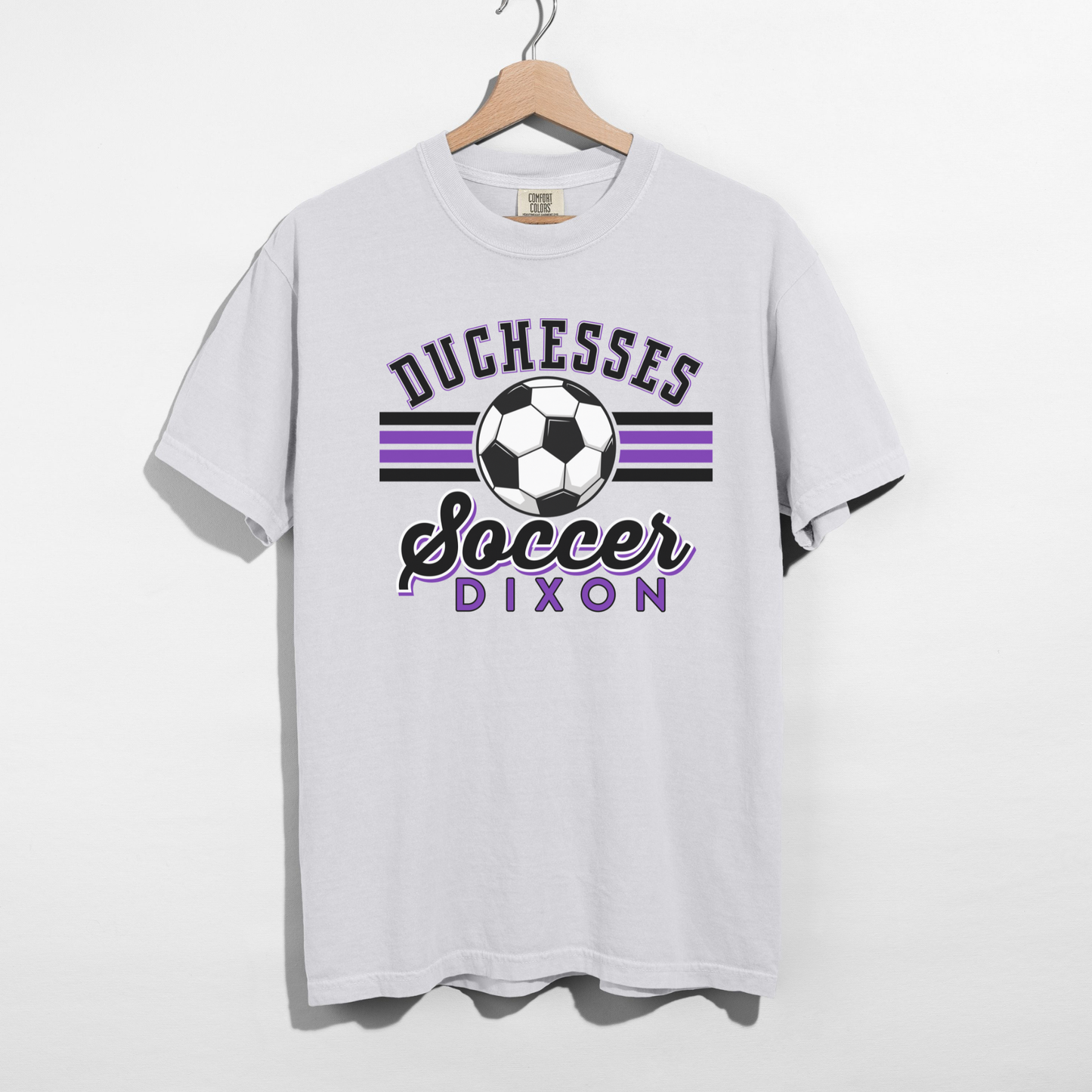 Duchesses Soccer Dixon graphic printed on white Comfort Colors t-shirt hanging on hanger